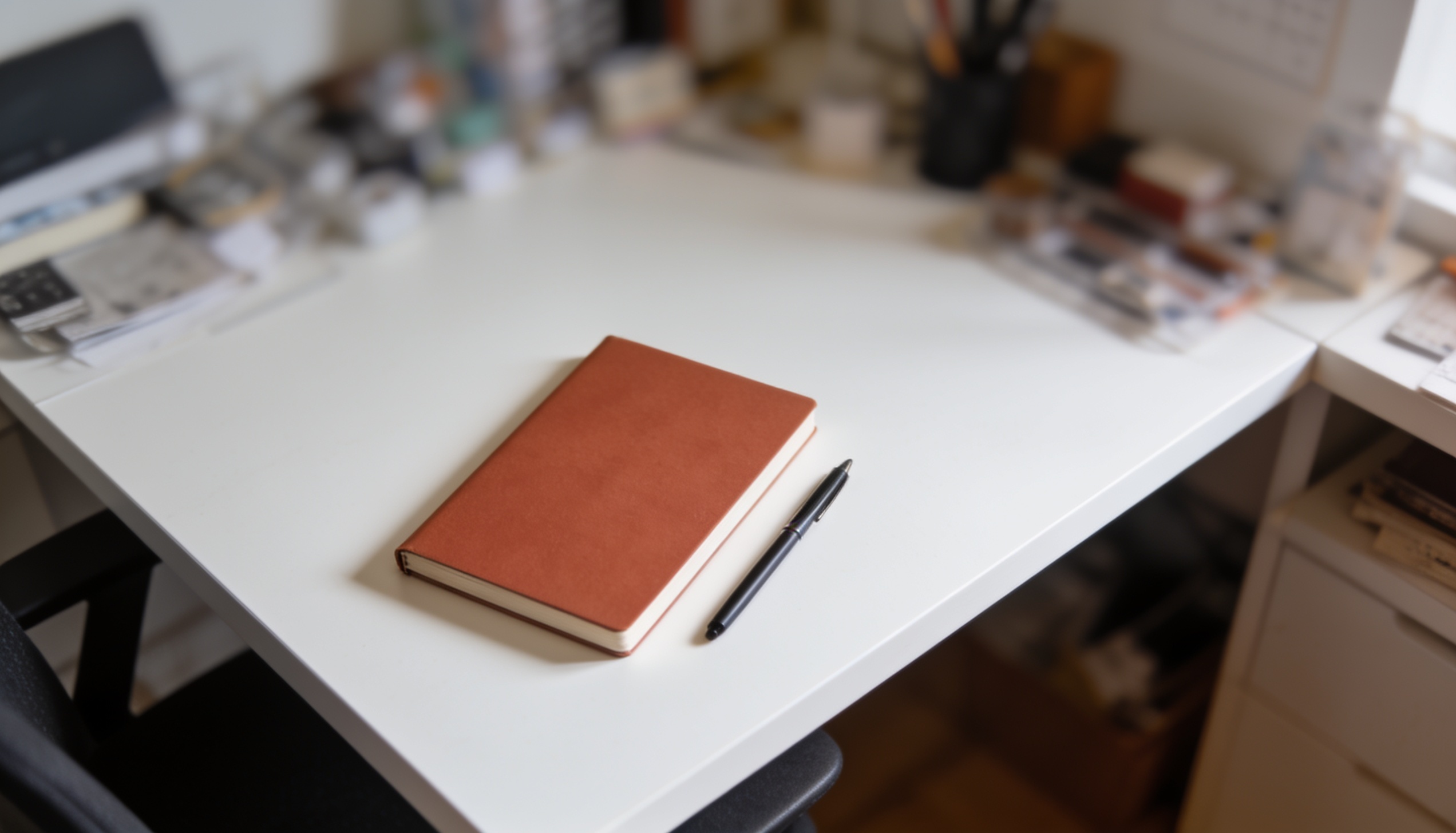 Mesa minimalista com apenas um caderno e caneta em destaque, representando o conceito de essencialismo — fazer menos, porém melhor
